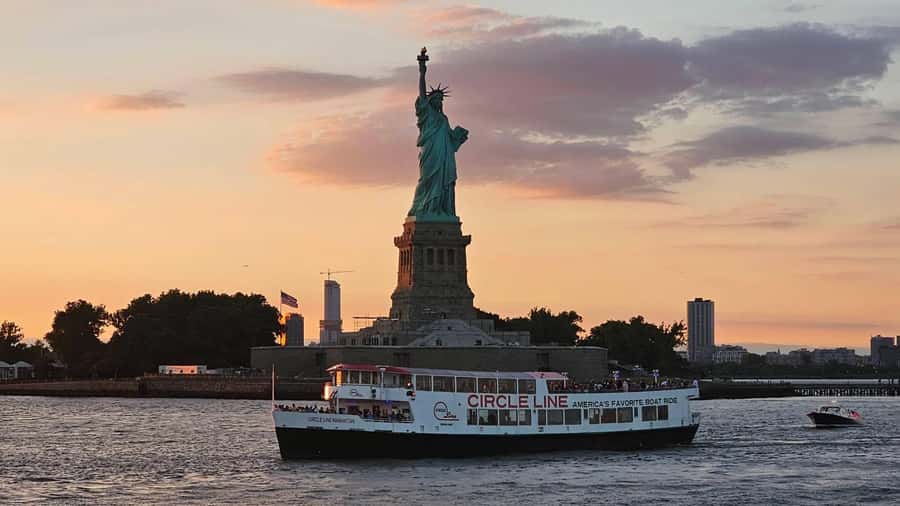 NYC: Statue of Liberty Sunset Cruise Skip-the-Line Ticket - Leaving Lower Manhattan in daylight